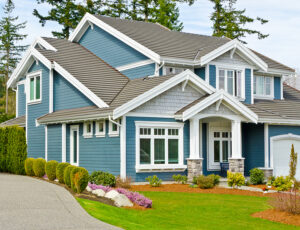 A lovely house with blue siding, white trim, and white replacement windows